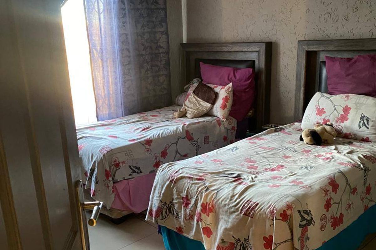 A bedroom featuring tiled flooring, textured wall finishes, and decorative cove cornicing.