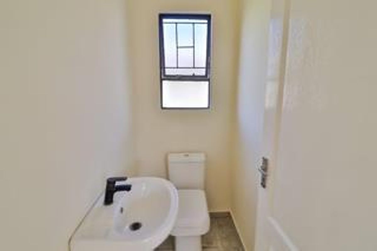 A clean and functional guest bathroom featuring a pedestal basin, modern tapware, and a toilet.
