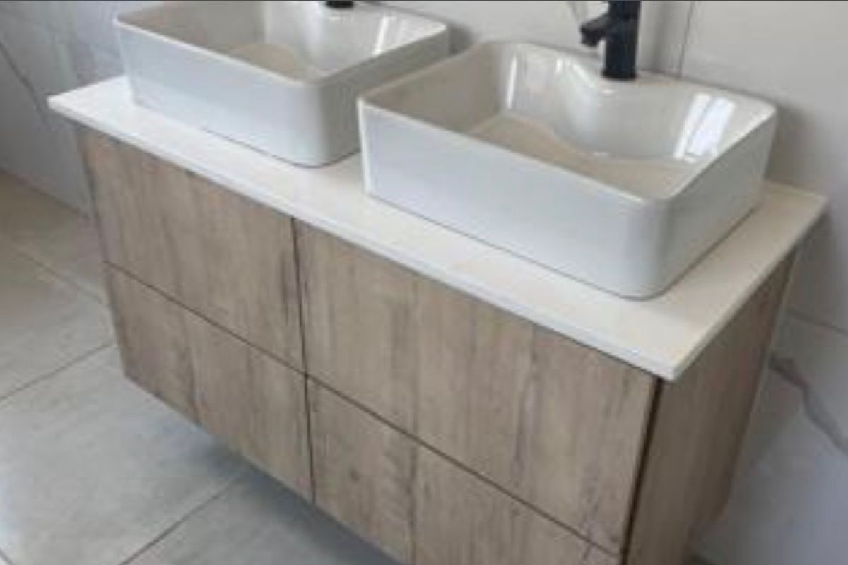 Modern bathroom vanity featuring a double vessel sink setup with wood-look cabinetry and black fixtures.