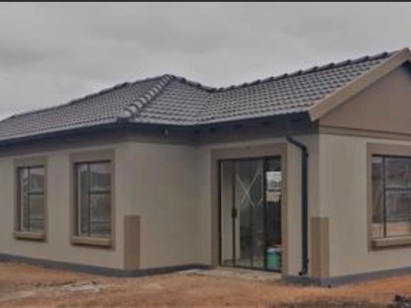 A modern single-story residential home featuring a tiled roof, plastered exterior walls, and aluminium-framed windows with a sliding glass entrance door.