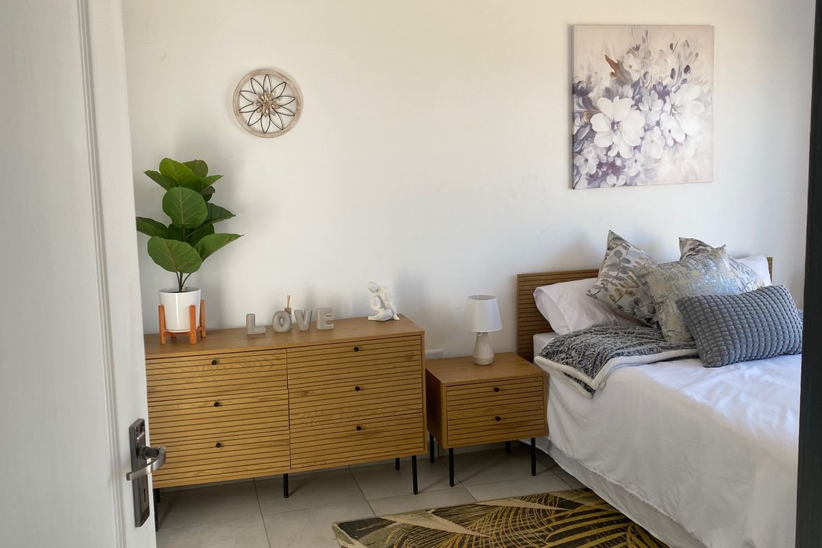 A well-maintained bedroom featuring neutral tiled flooring and a classic tongue and groove ceiling with recessed lighting.