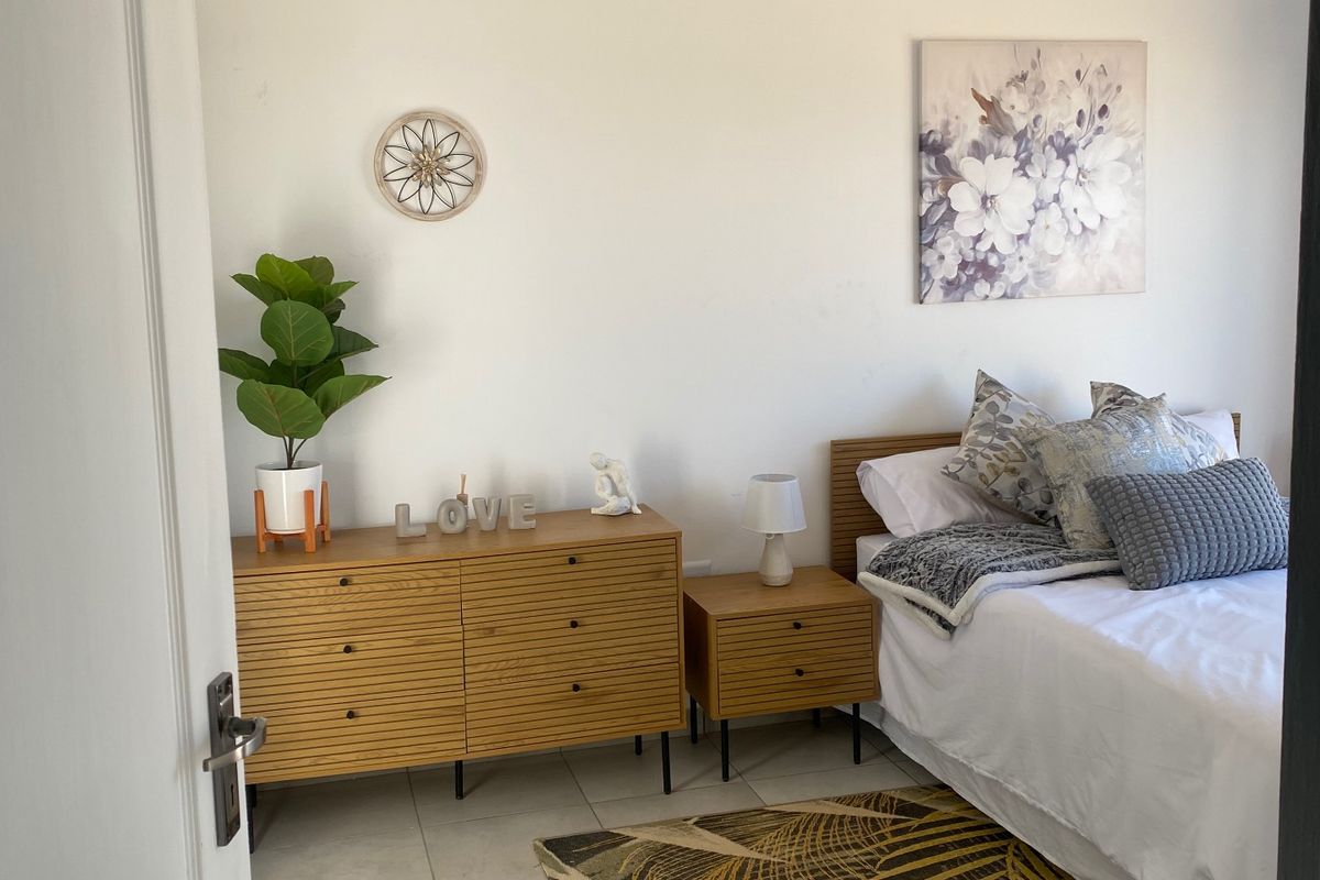 A well-maintained bedroom featuring neutral tiled flooring and a white tongue and groove ceiling with recessed lighting.