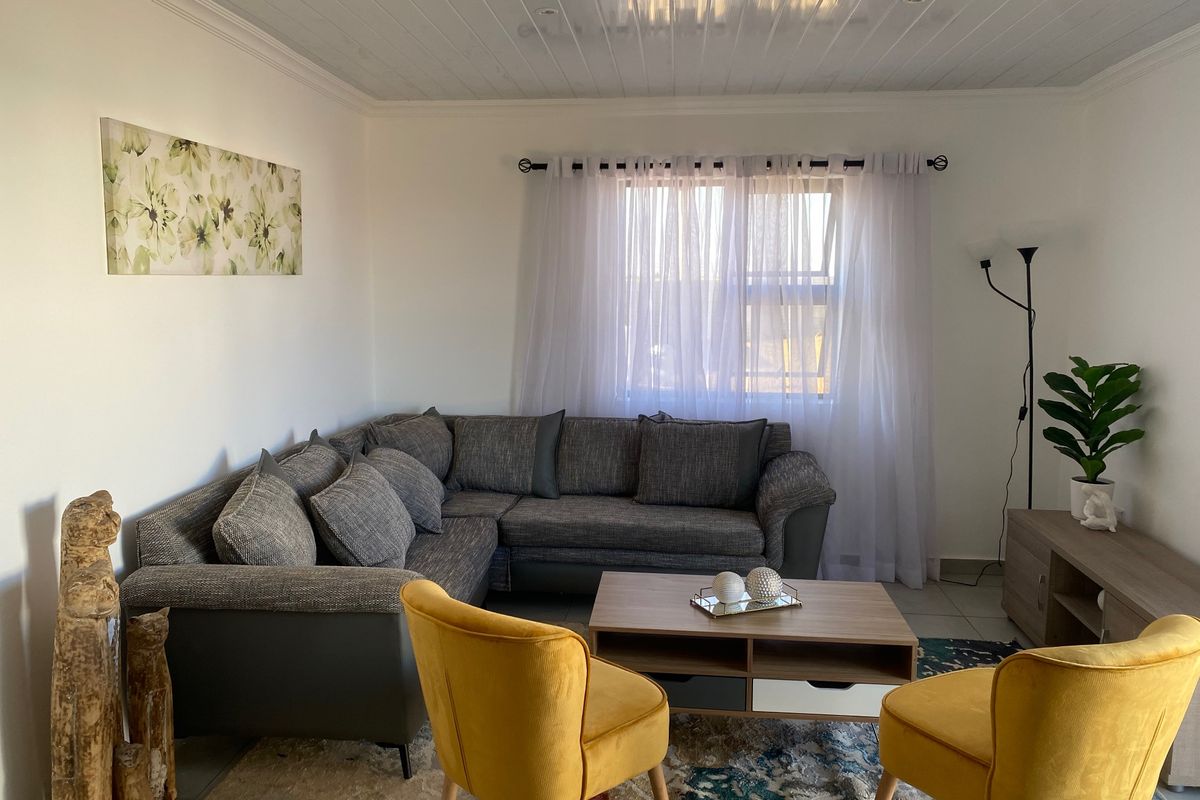 A well-maintained living room featuring a tongue and groove ceiling and tiled flooring, providing a comfortable and inviting space.