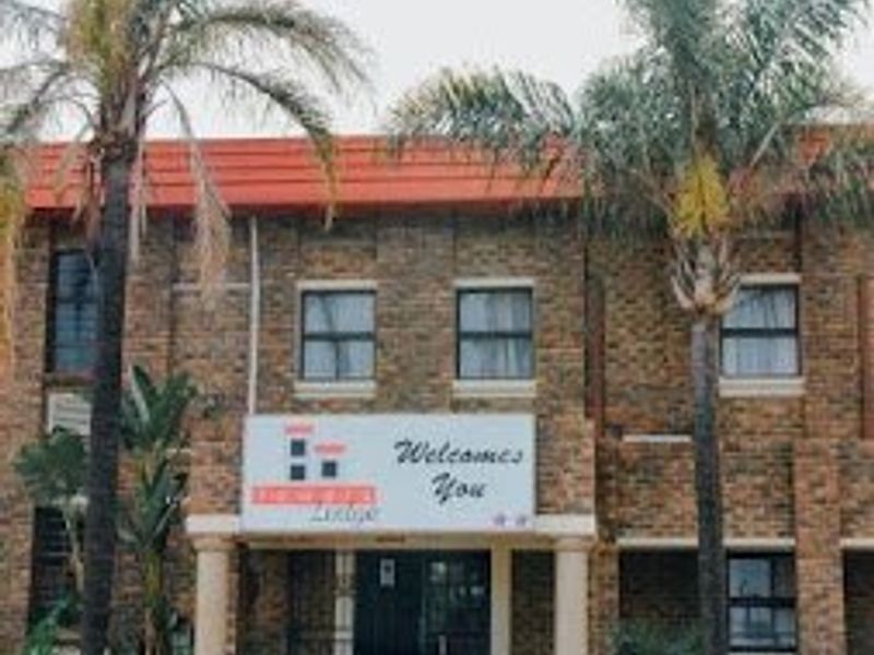 Front elevation of a commercial lodge building featuring face brick construction, a tiled roof, and a prominent entrance with concrete columns.