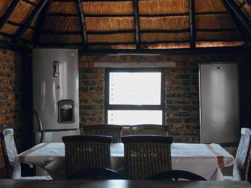 Dining area featuring rustic exposed brick walls and a traditional thatched roof with exposed timber rafters, creating a unique, character-filled atmosphere.