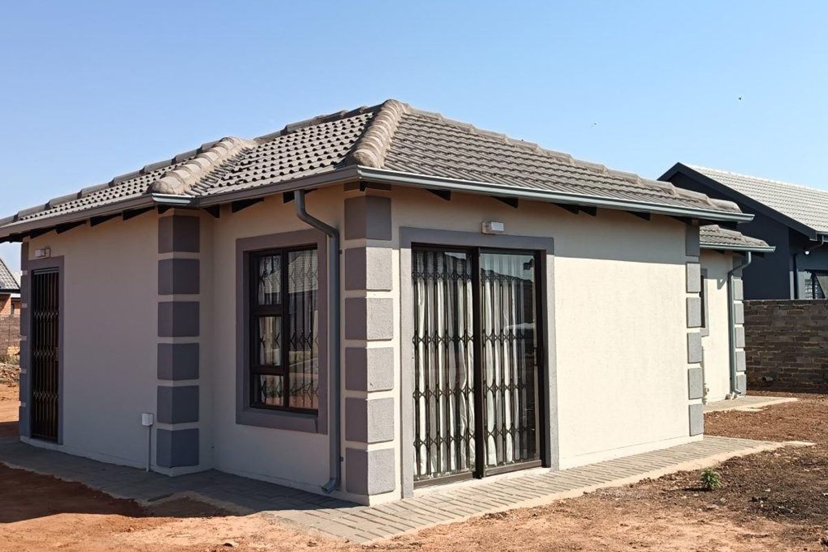 A well-maintained single-story residential structure featuring a tiled roof, aluminium window frames, and a sliding glass door with security gate.