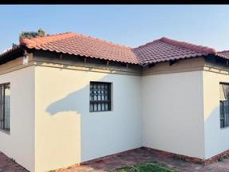 A view of the exterior front facade of the house featuring a tiled roof and security bars on the windows.