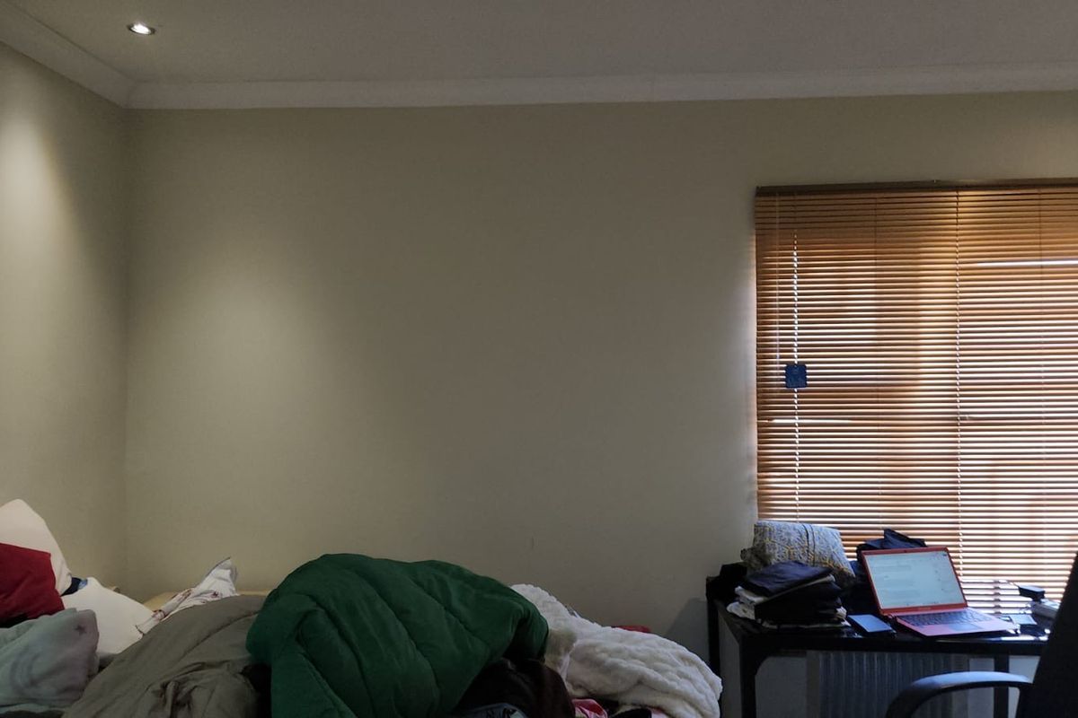 A bedroom featuring neutral wall finishes, recessed downlighting, and fitted venetian blinds.