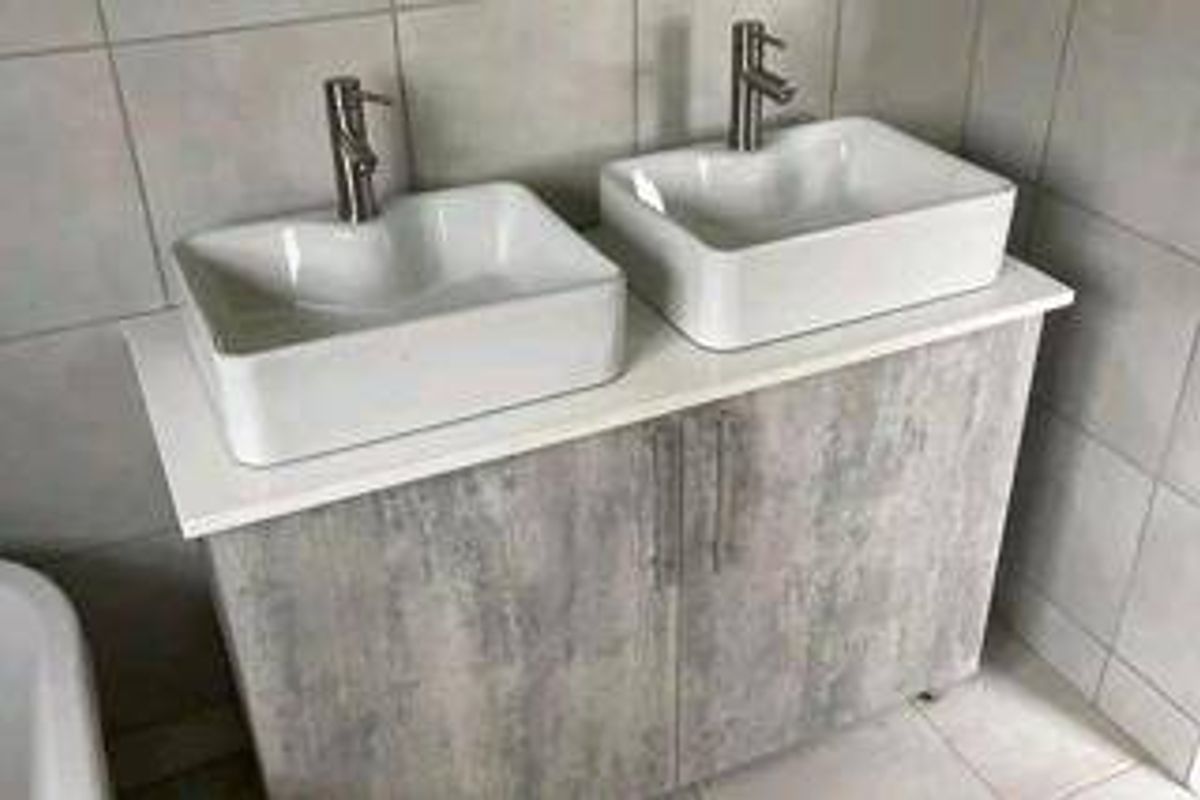 A modern bathroom vanity featuring a double vessel sink setup with contemporary mixer taps and a textured grey cabinet finish.