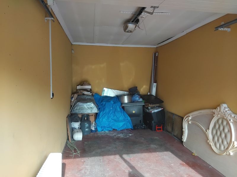 A single-car garage space featuring painted walls, a concrete floor, and an overhead garage door motor.