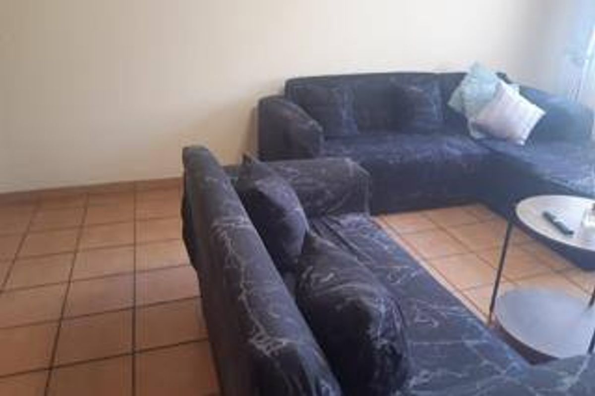 A living room area featuring ceramic floor tiles, providing a functional and neutral base for the space.
