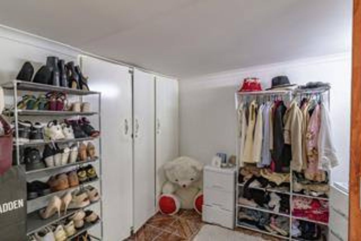 A bedroom featuring built-in cupboards, tiled flooring, and coved ceiling details.