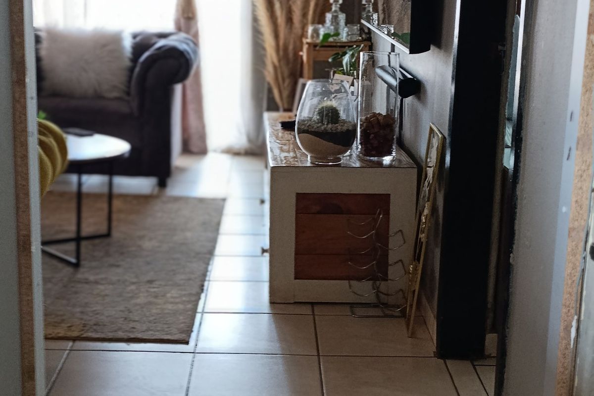 A view into a living room featuring ceramic floor tiles and a sliding glass door leading to an outdoor area.