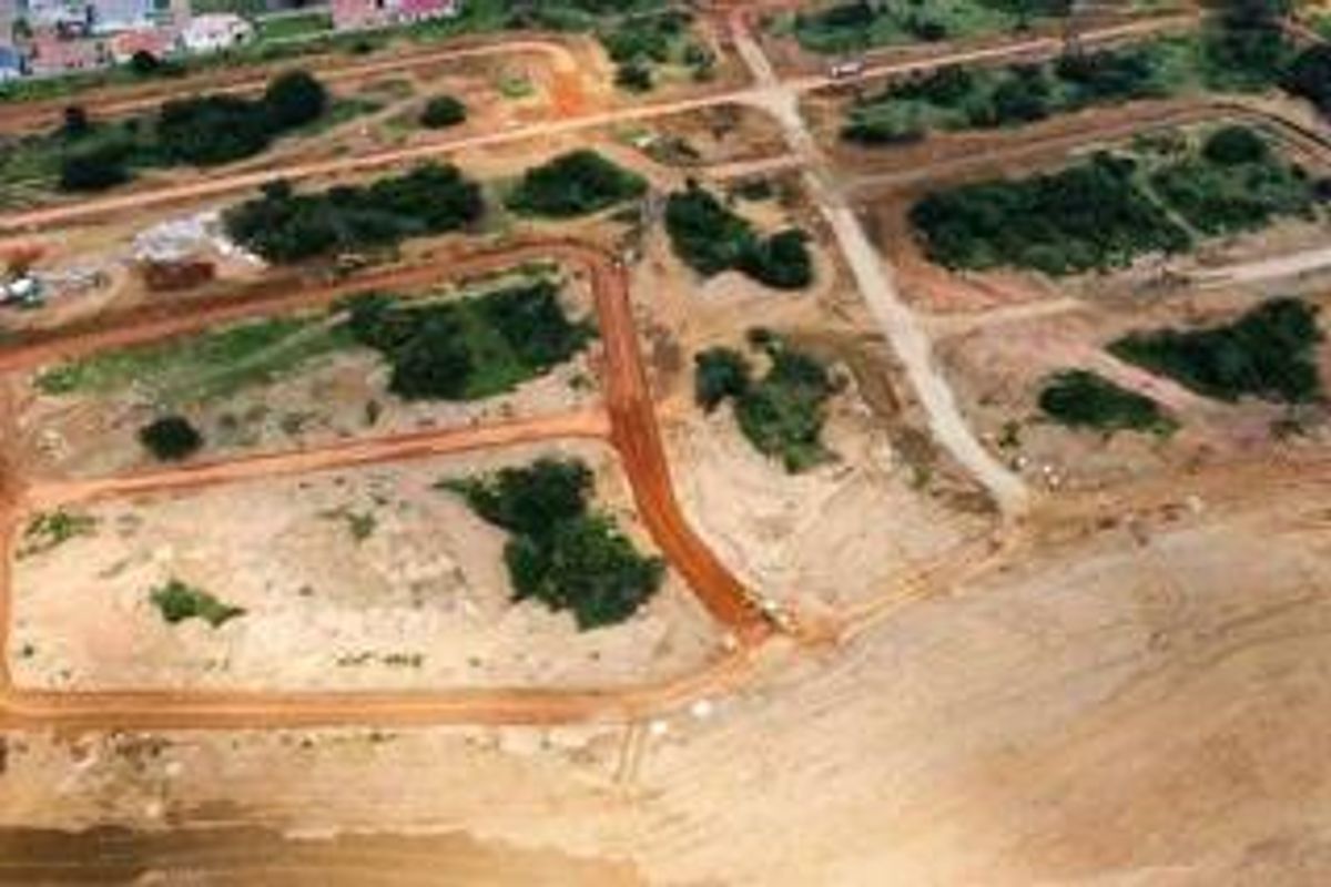 Aerial view of an undeveloped residential land development site showing cleared plots and unpaved road networks.