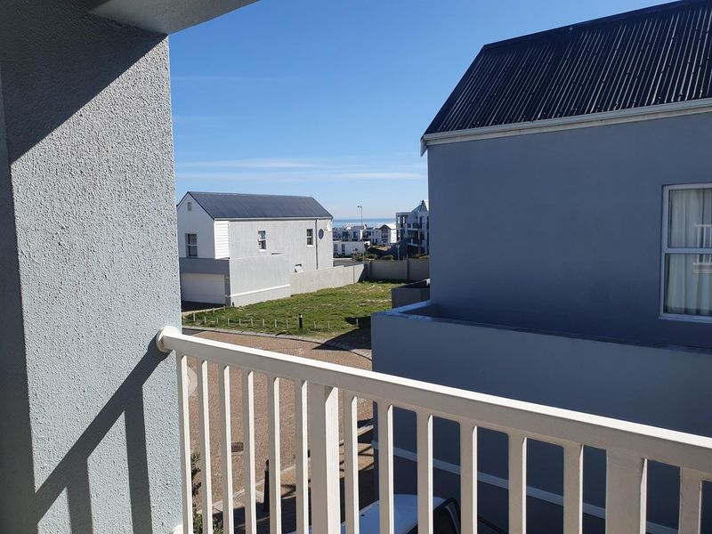 An elevated balcony view overlooking the surrounding residential neighborhood and nearby coastal area.