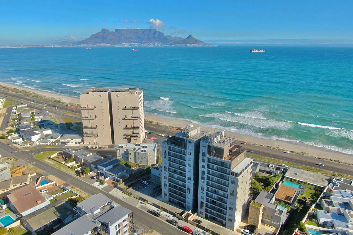 Aerial view of the coastal apartment complex featuring direct ocean views and proximity to the beach.