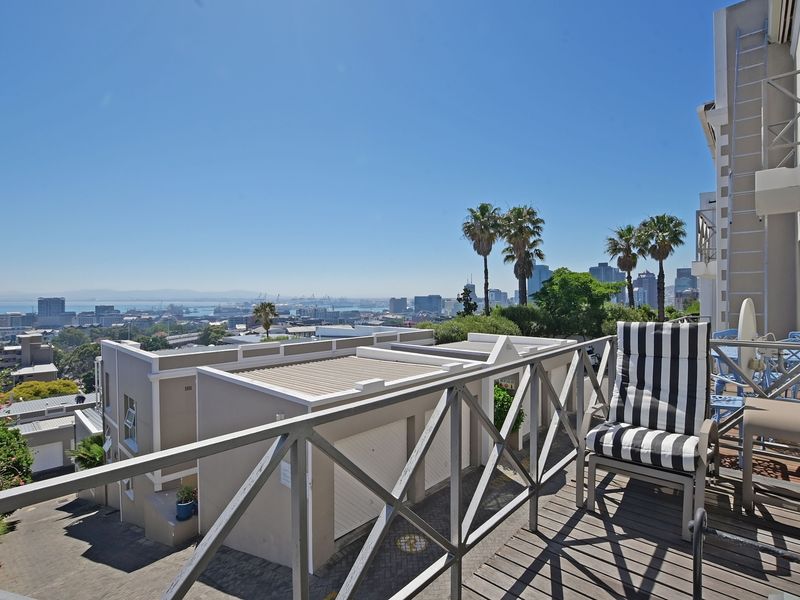 Spacious balcony featuring timber decking and balustrades, offering elevated views over the surrounding neighborhood and city skyline.