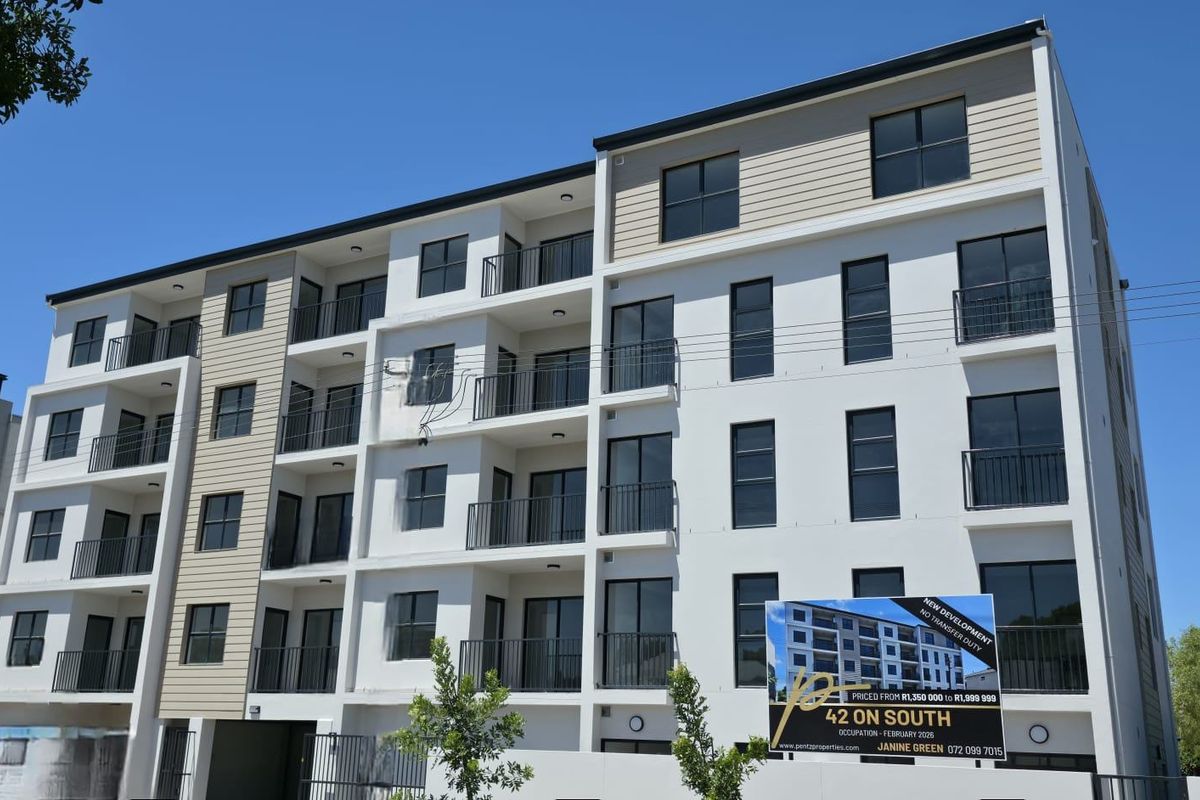 Modern multi-story apartment building facade featuring clean white finishes, dark window frames, and private balconies for each unit.