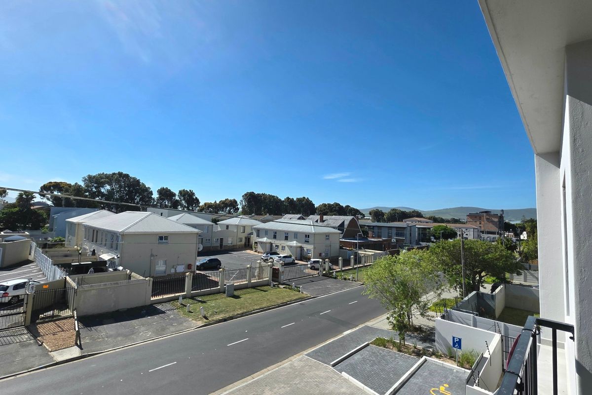Elevated view overlooking the surrounding residential complex, street, and neighborhood landscape from the apartment balcony.
