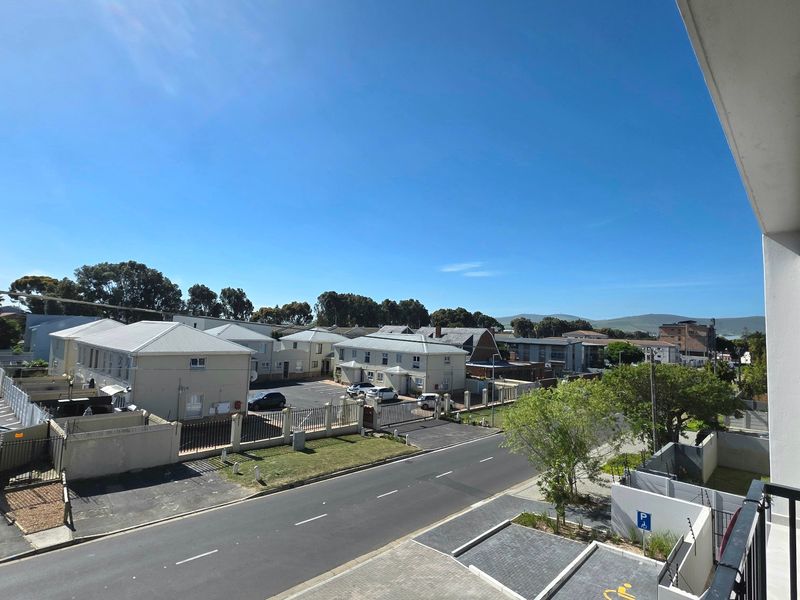 Elevated view overlooking the surrounding residential complex, street, and neighborhood landscape from the apartment balcony.