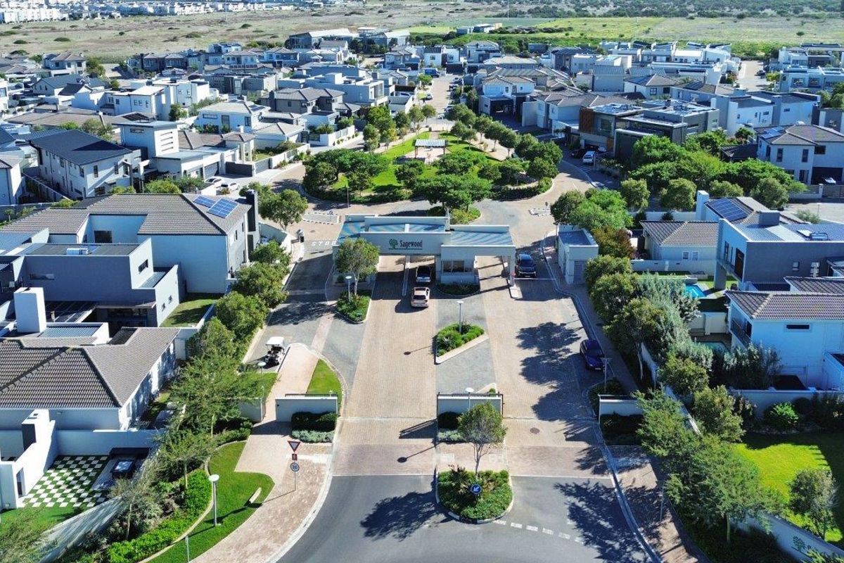 Aerial view of the Sagewood estate entrance, featuring paved roads, landscaped gardens, and modern residential housing units.