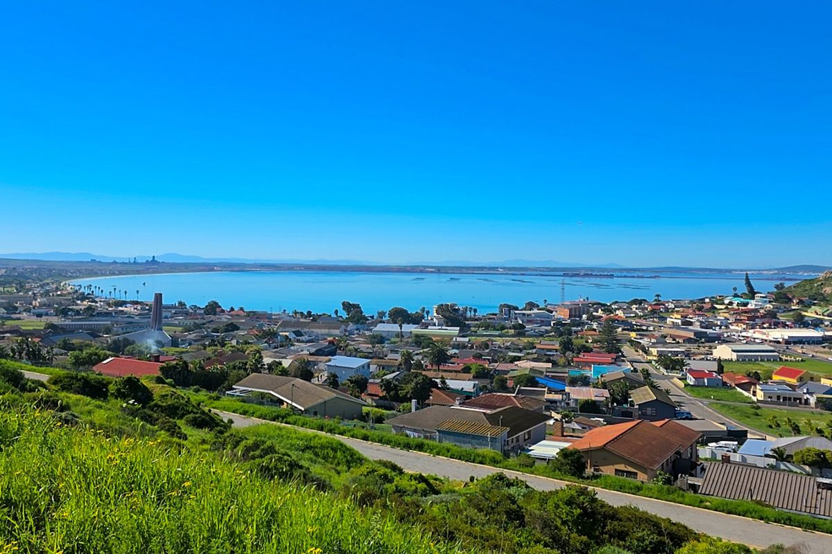 A scenic elevated view overlooking the coastal town and bay, showcasing the surrounding landscape and residential area.