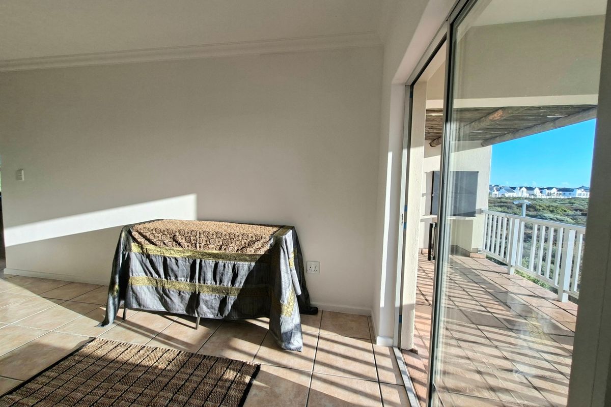 Bright living area featuring tiled flooring and large sliding glass doors that open onto a private balcony with scenic views.