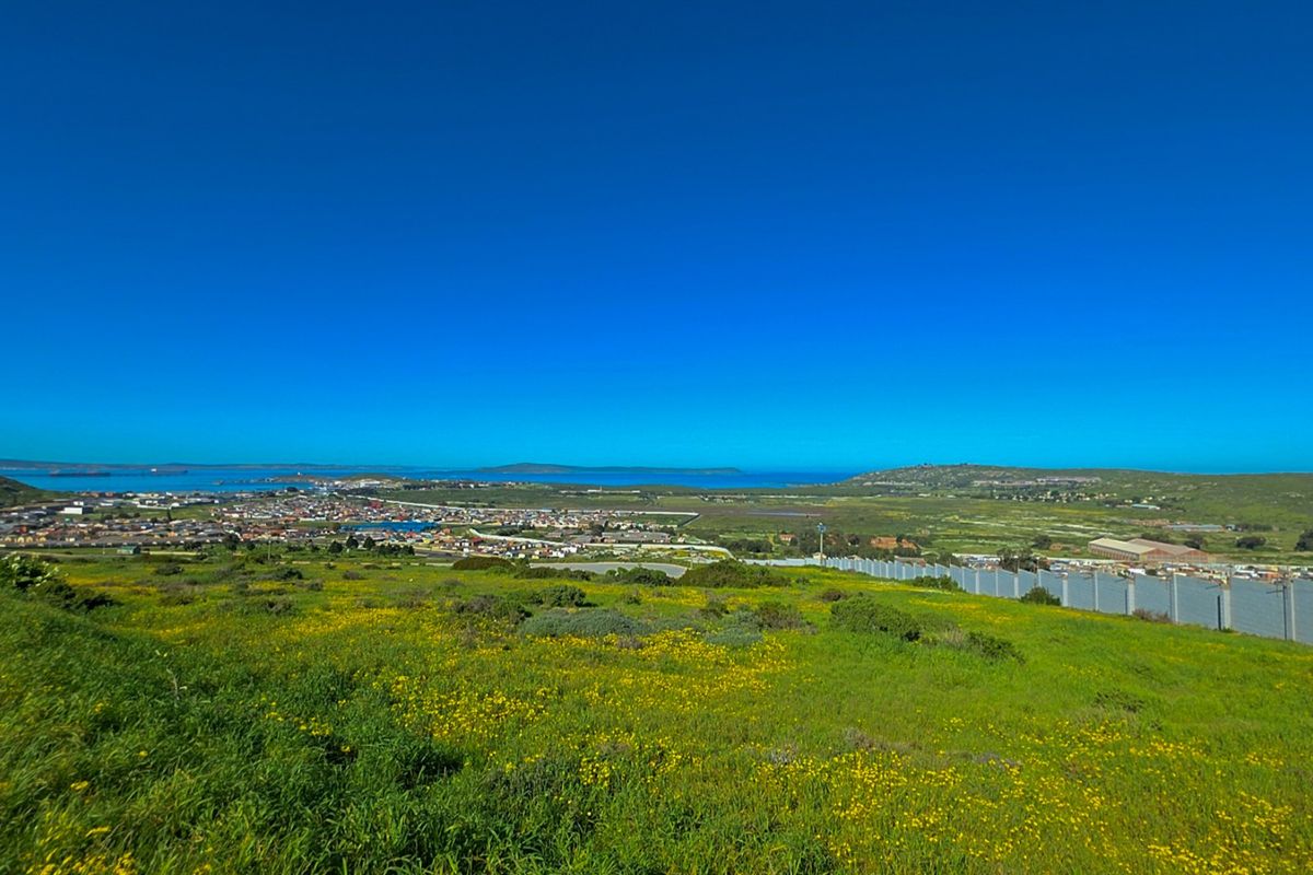 Expansive elevated view overlooking the surrounding landscape, coastal town, and ocean horizon from the vacant residential land.