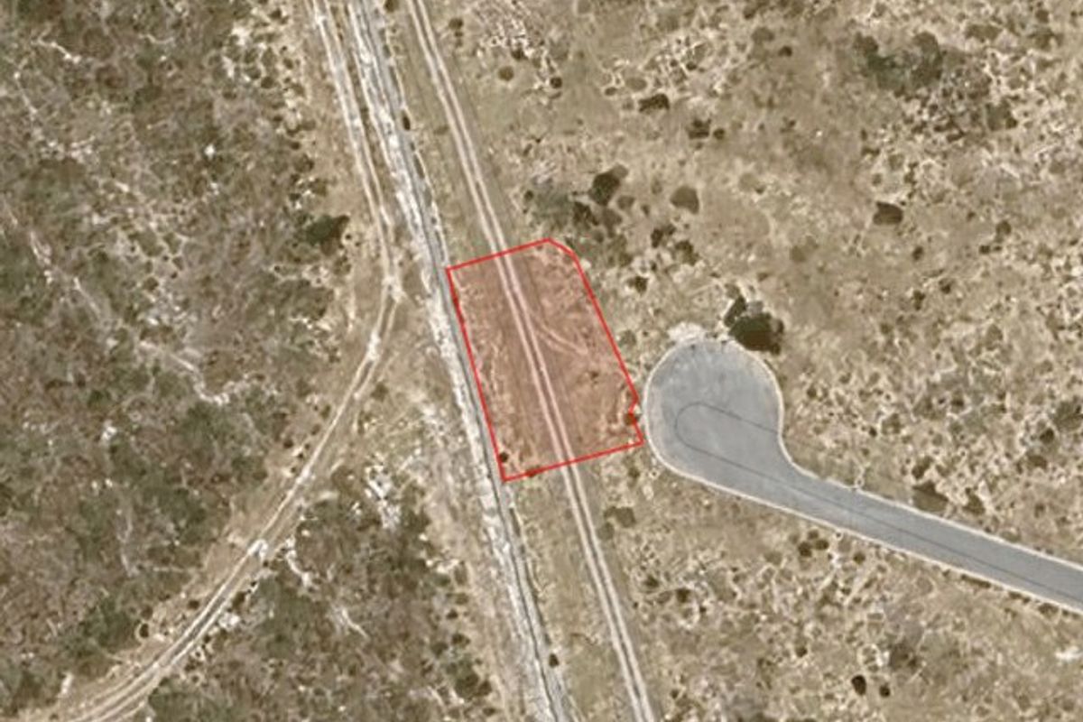 Aerial view of a vacant residential land plot with clear boundary markings, situated in a developing neighborhood.