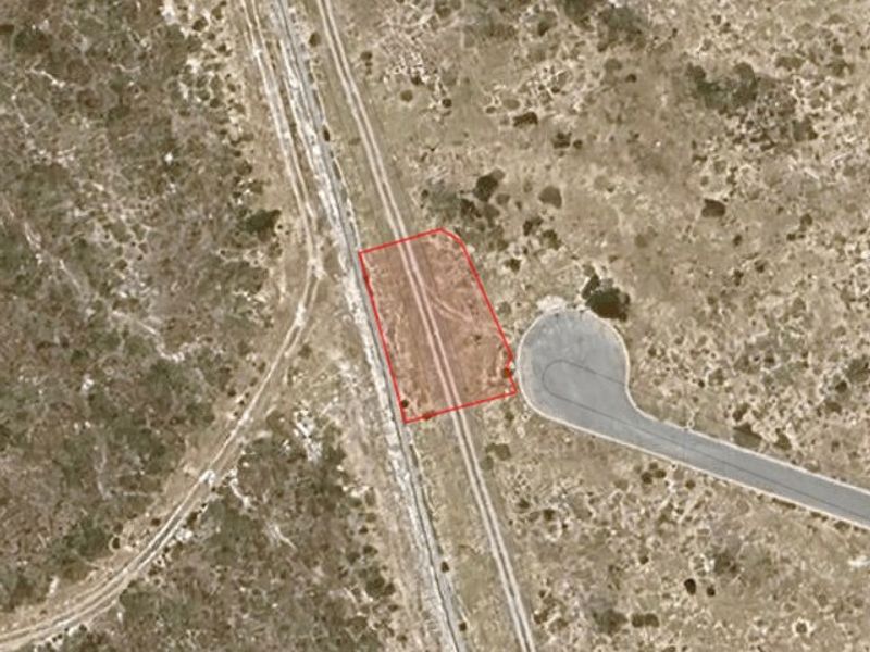 Aerial view of a vacant residential land plot with clear boundary markings, situated in a developing neighborhood.