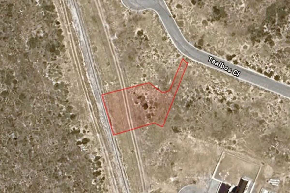 Aerial satellite view of a vacant residential plot outlined in red, situated near a cul-de-sac and adjacent to a railway line.