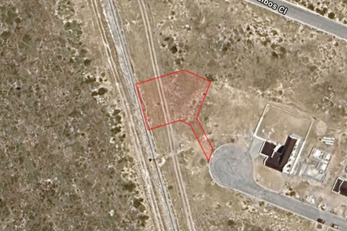 Aerial view of a vacant residential plot highlighting the property boundaries and access from the adjacent street.