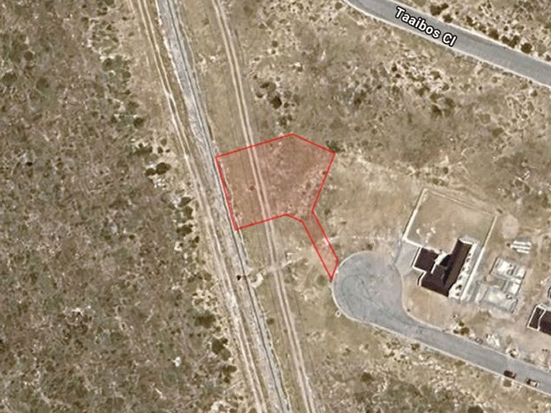 Aerial view of a vacant residential plot highlighting the property boundaries and access from the adjacent street.