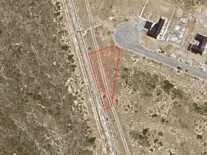 Aerial satellite view showing the vacant residential plot boundaries within the surrounding landscape and nearby street infrastructure.