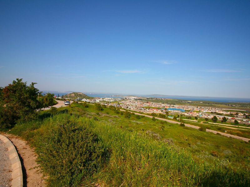 A scenic elevated view overlooking the surrounding landscape, coastal town, and distant ocean horizon from the residential property.