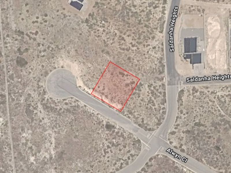 Aerial view of a vacant residential land plot highlighted in red, situated within a developed street network.