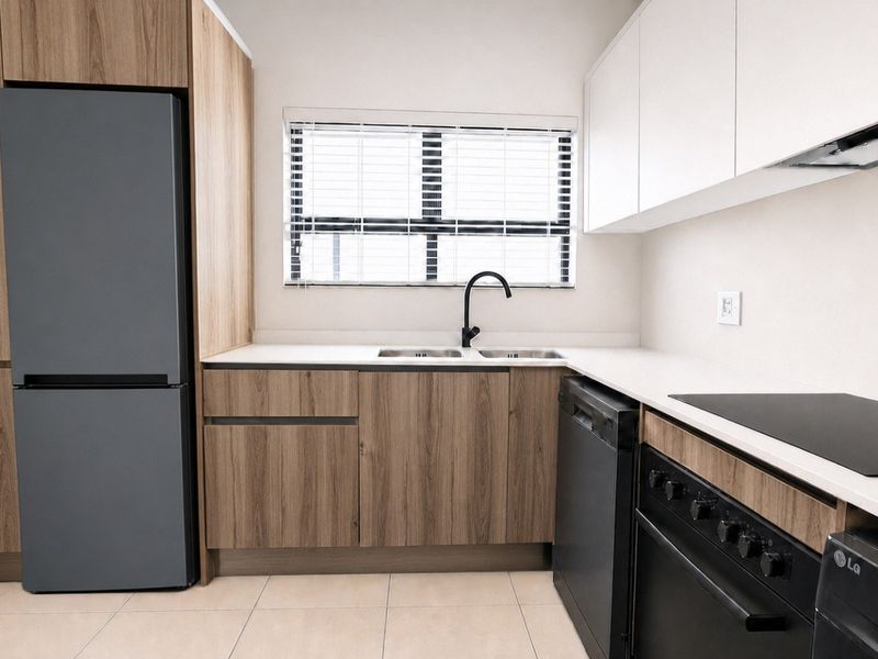 Modern kitchen featuring wood-grain and white cabinetry, stone countertops, integrated appliances, and a sleek black mixer tap with a double basin sink.