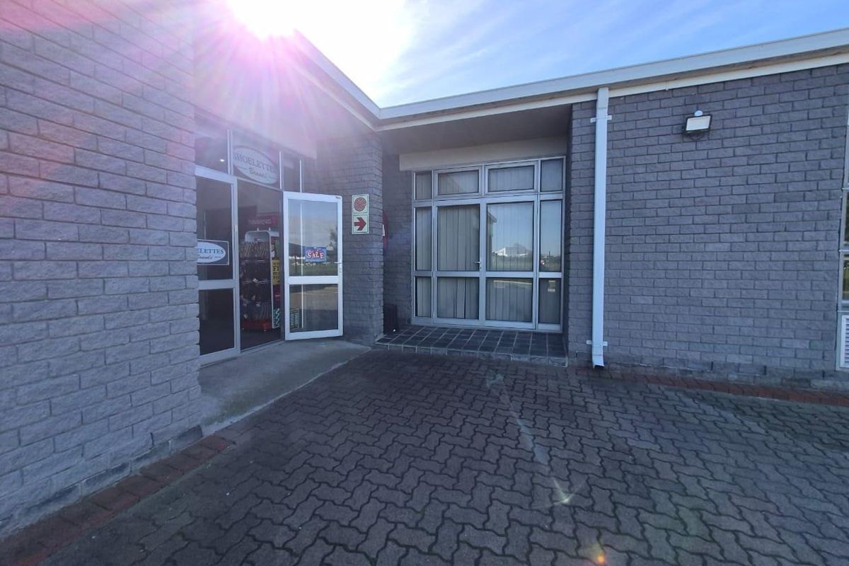 Front entrance of a commercial property featuring a brick facade, paved driveway, and aluminium framed glass doors and windows.