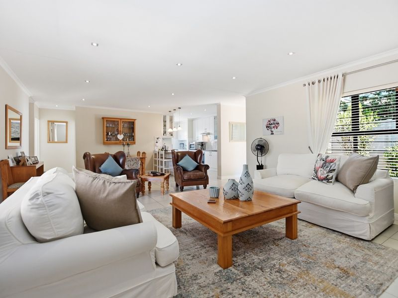 Spacious open-plan living area featuring tiled floors, recessed lighting, and a seamless flow into the adjacent kitchen space.