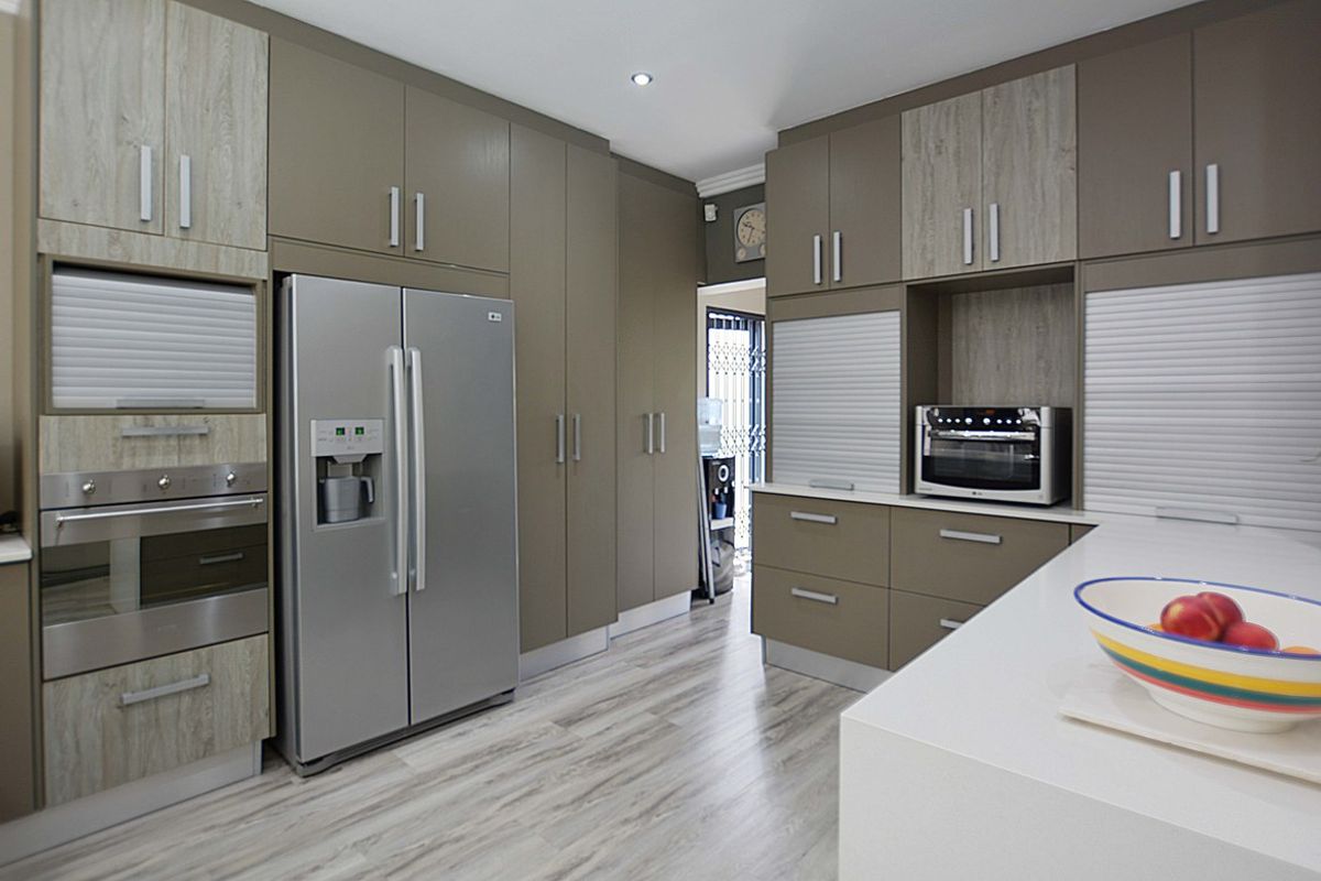 Modern kitchen featuring sleek cabinetry, integrated oven, built-in microwave, and stone countertops with a clean, contemporary finish.
