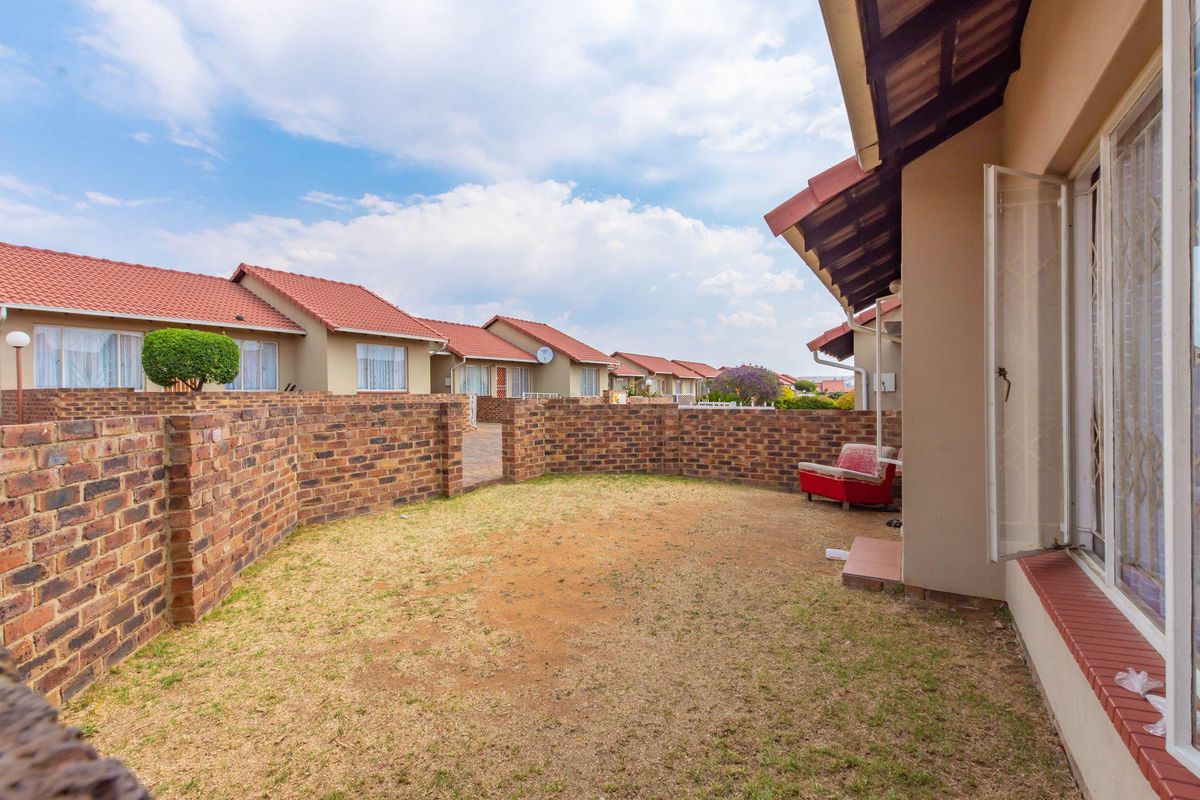 A private rear garden area featuring a brick boundary wall and direct access to the apartment interior.