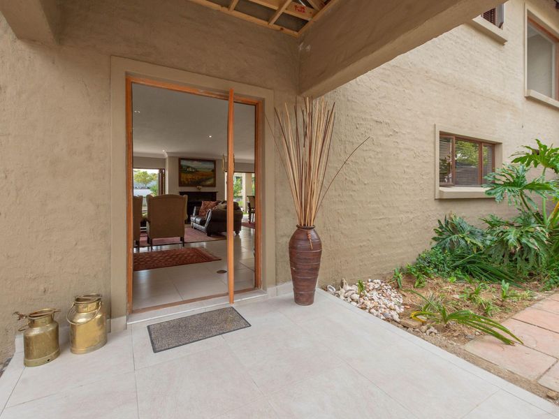 Covered entrance patio featuring tiled flooring and direct access into the main living area through a large glass door.