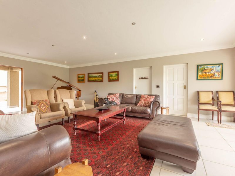 Spacious living room featuring tiled flooring, recessed downlighting, and direct access to adjacent areas through multiple doorways.