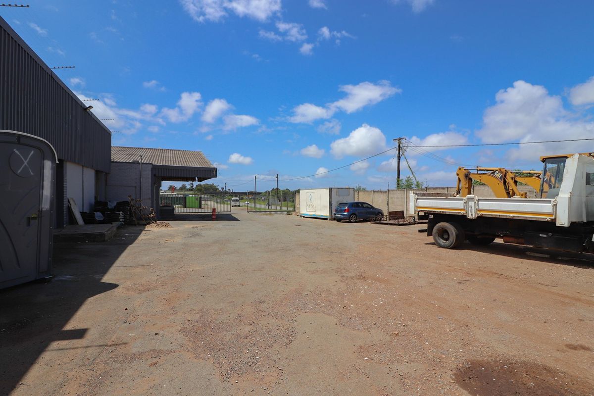 Expansive commercial yard area featuring industrial building access, perimeter fencing, and open storage space suitable for logistics or heavy equipment operations.