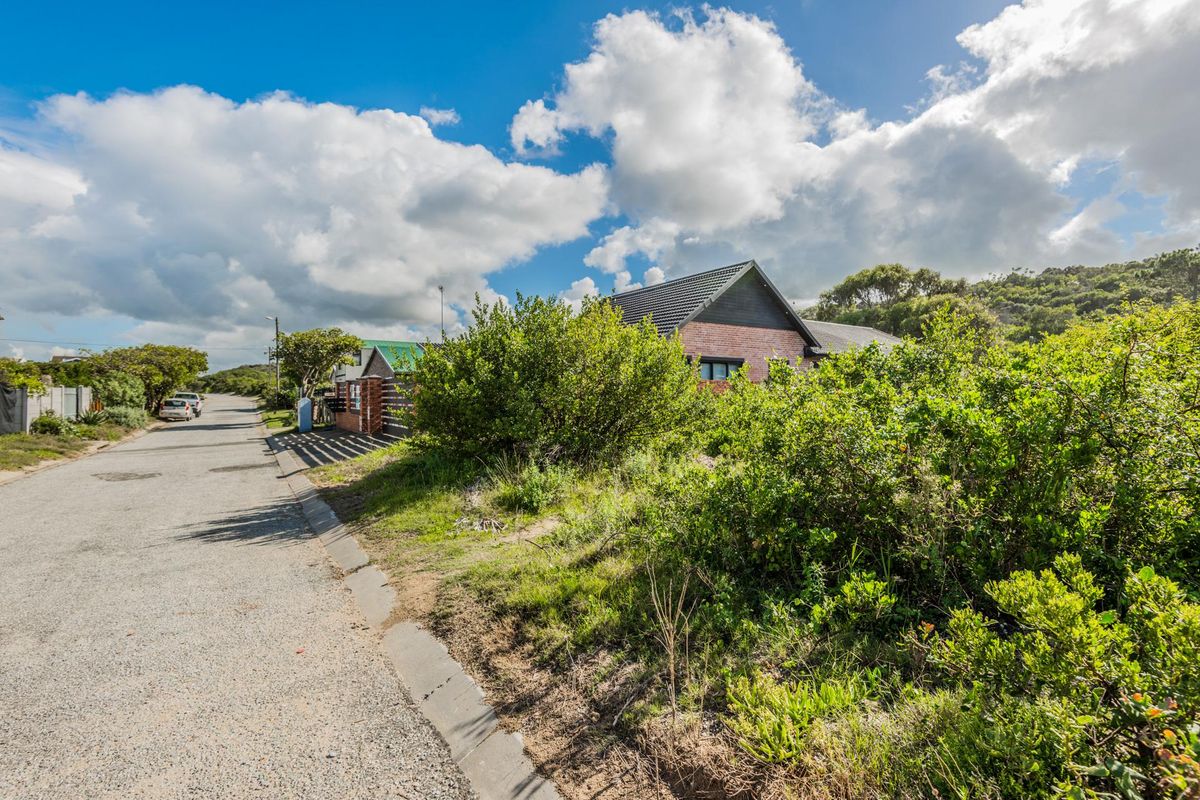 A street-level view of the residential property showing the paved road, kerbing, and the exterior facade of the dwelling with a tiled roof.