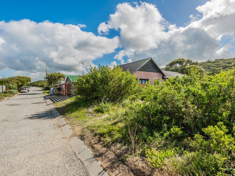 A street-level view of the residential property showing the paved road, kerbing, and the exterior facade of the dwelling with a tiled roof.