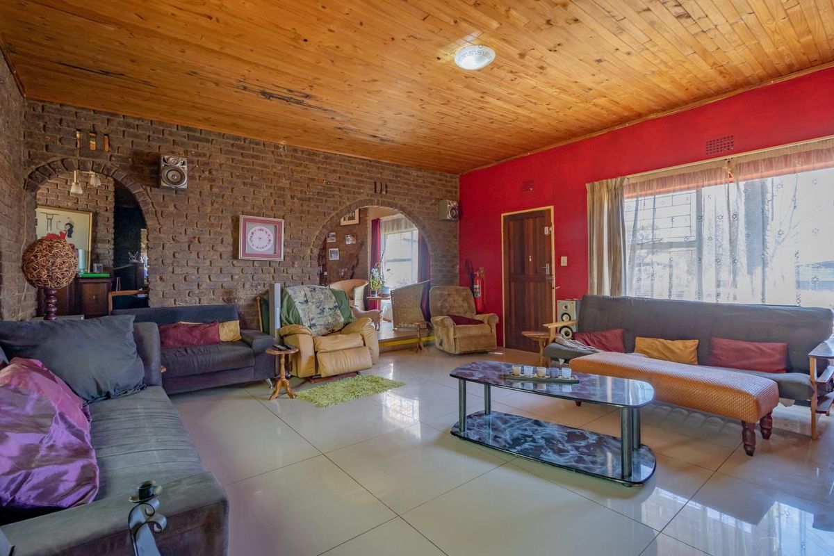 Spacious living area featuring exposed brick walls, arched doorways, and a timber-clad ceiling, providing a rustic and character-filled atmosphere.