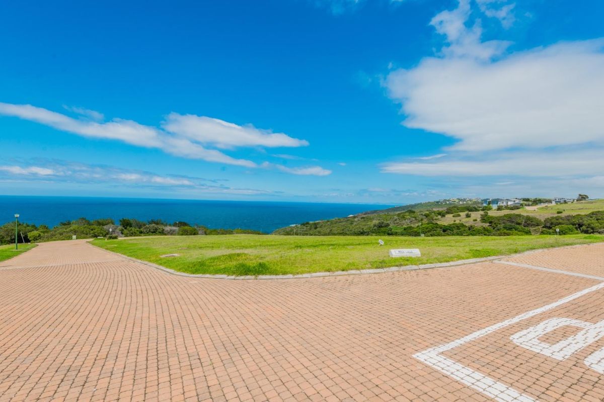 A vacant residential plot featuring expansive ocean views and established paved access, offering a prime location for a coastal home build.