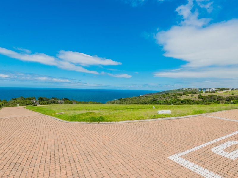 A vacant residential plot featuring expansive ocean views and established paved access, offering a prime location for a coastal home build.