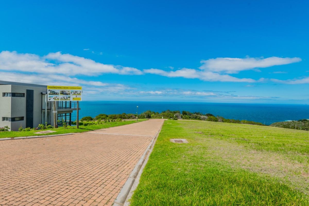 A vacant residential plot featuring a paved driveway and expansive, unobstructed ocean views.